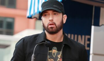 Eminem îmbrăcat casual cu un hanorac negru și o șapcă asortată