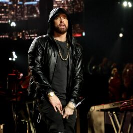 Eminem îmbrăcat într-o ținută complet neagră asortată cu un lanț gros din aur