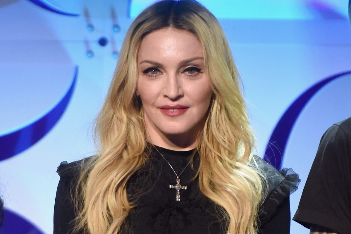 Madonna îmbrăcată într-o ținută neagră accesorizată cu un lănțișor cu cruciuliță