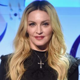 Madonna îmbrăcată într-o ținută neagră accesorizată cu un lănțișor cu cruciuliță