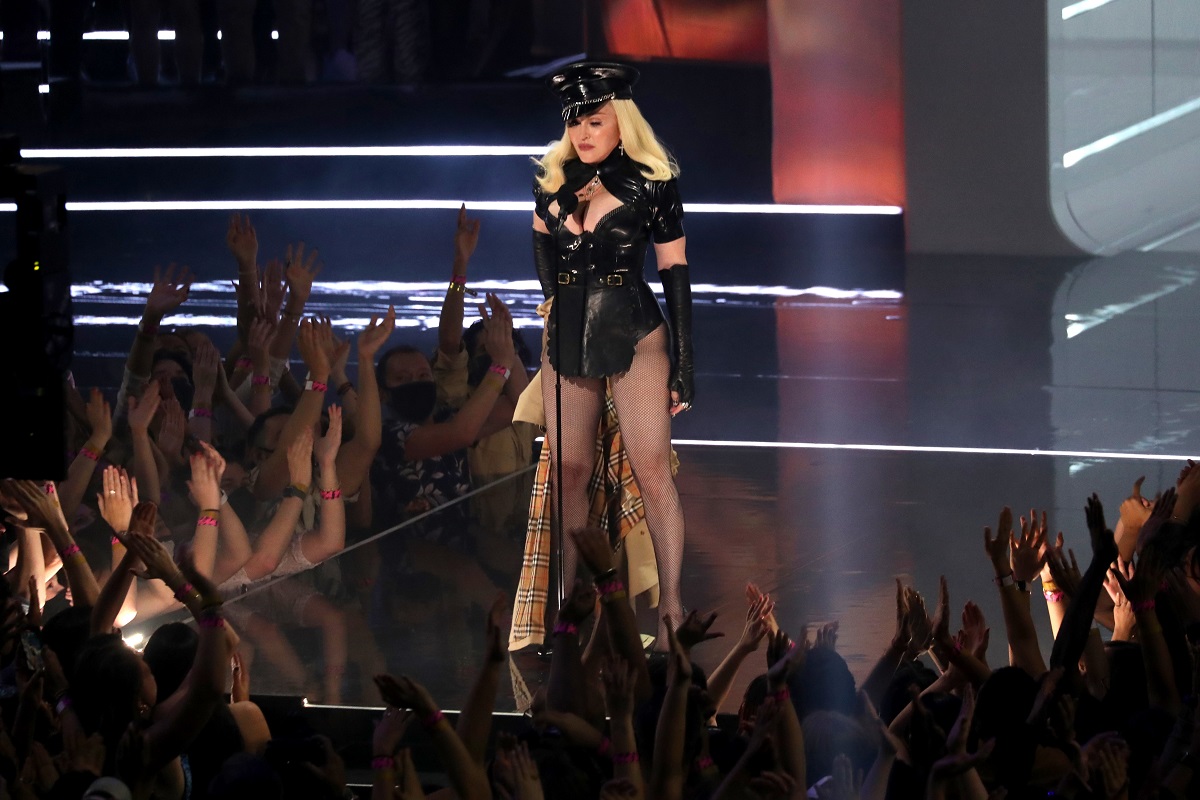 Madonna îmbrăcată într-o ținută sexy neagră de polițist în timp ce cântă pe scenă