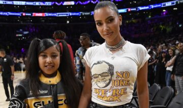 North West și Kim Kardashian îmrăcate casual cu o bluză și tricou la un meci de baschet