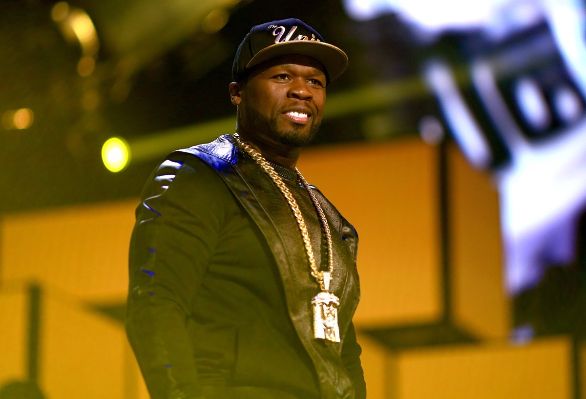 50 Cent îmbrăcat într-o ținută neagră asortată cu un lanț strălucitor