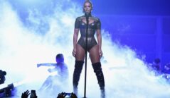 Beyonce îmbrăcată într-un body sexy de culoare gri în timp ce cântă la microfon