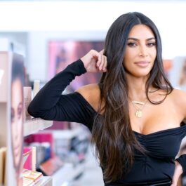 Kim Kardashian îmbrăcată într-o bluză neagră mulată cu un decolteu adânc