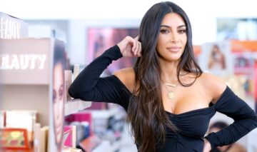 Kim Kardashian îmbrăcată într-o bluză neagră mulată cu un decolteu adânc